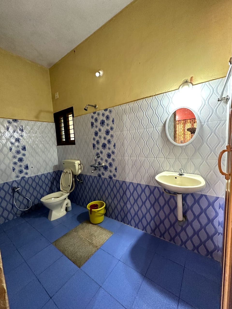 Clean tiled attached bathroom with western toilet at Satish Mullodi Home Stay